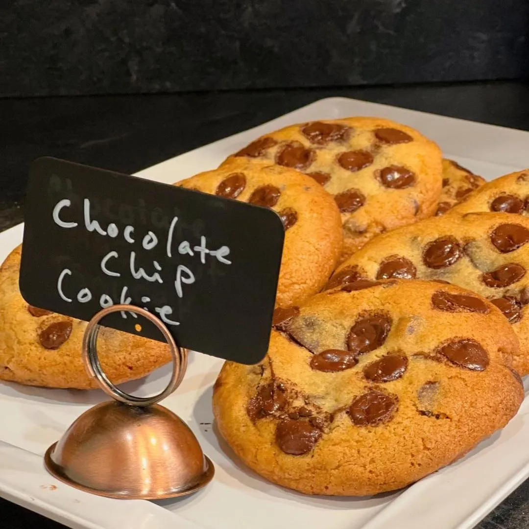 Fresh chocolate chip cookies on a platter by the register