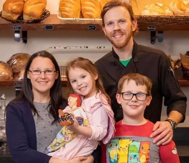 Matt and Jessica Weafer with their two children in front of the Niko's bread shelves